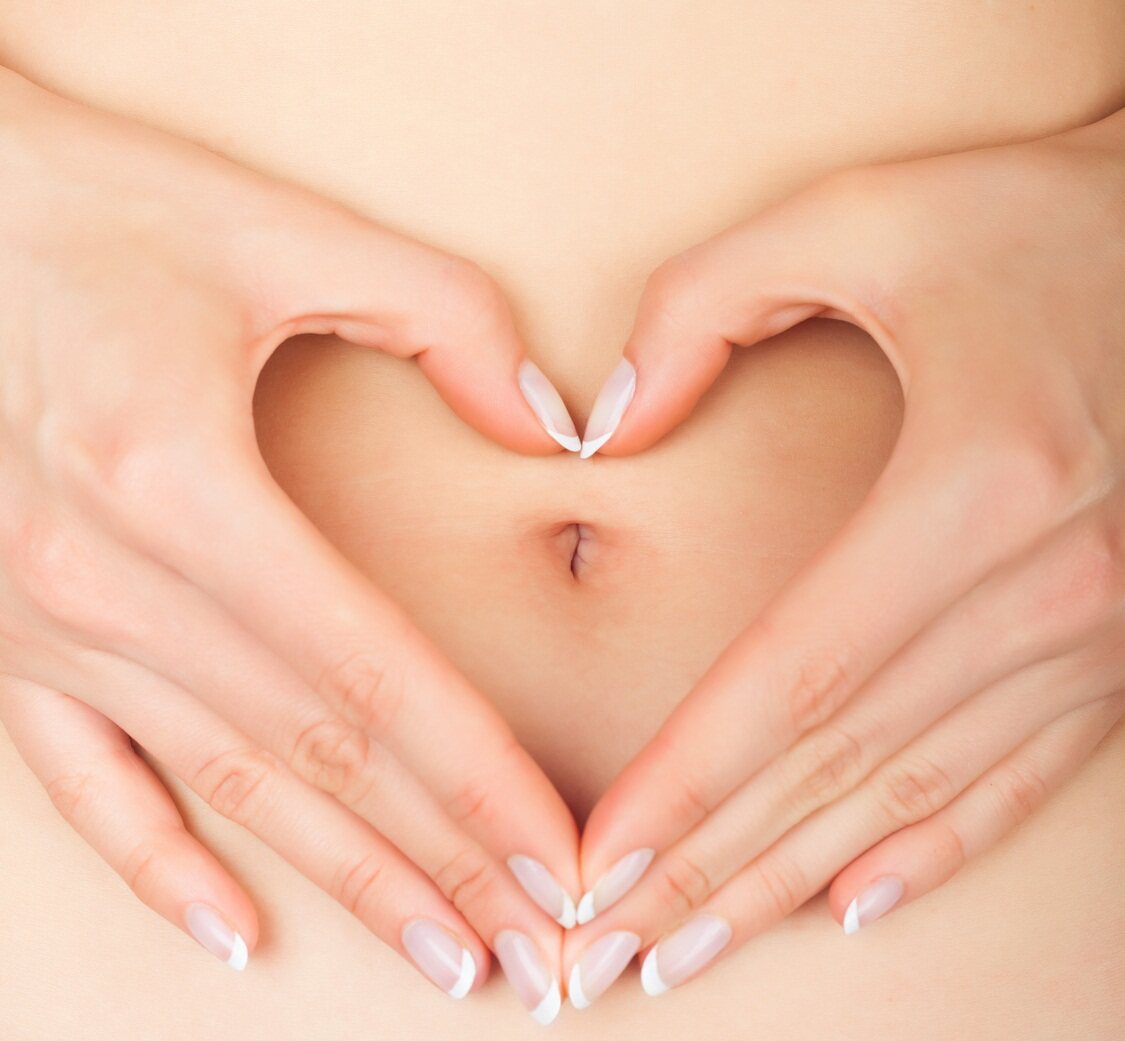 Hands making a heart shape around the belly