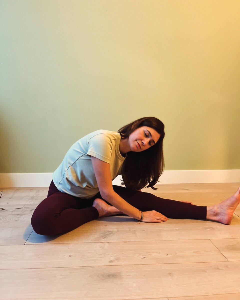 A seated stretch on the studio floor